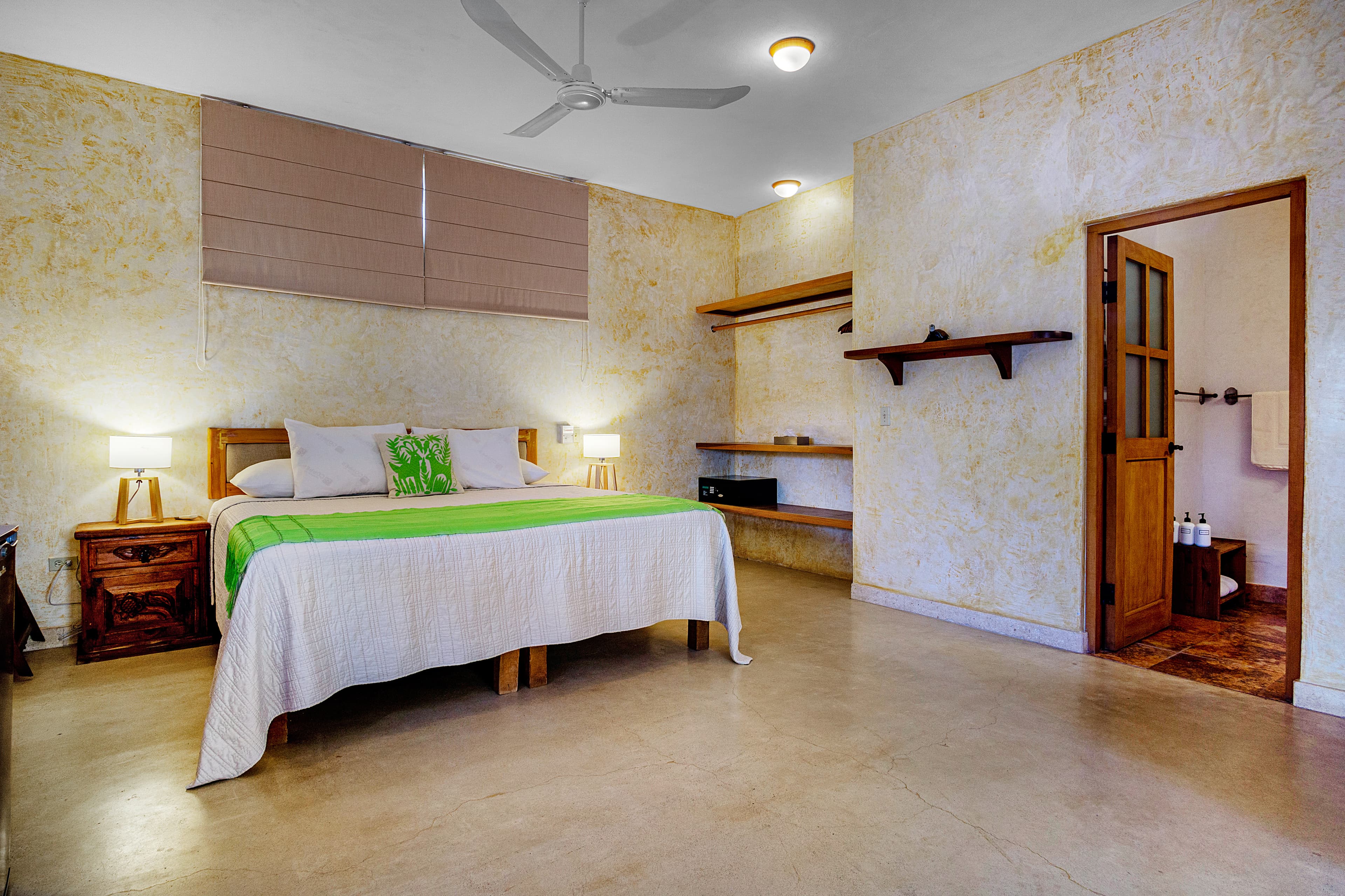 A minimalistic bedroom with a wooden bed, green accents, and soft lighting.