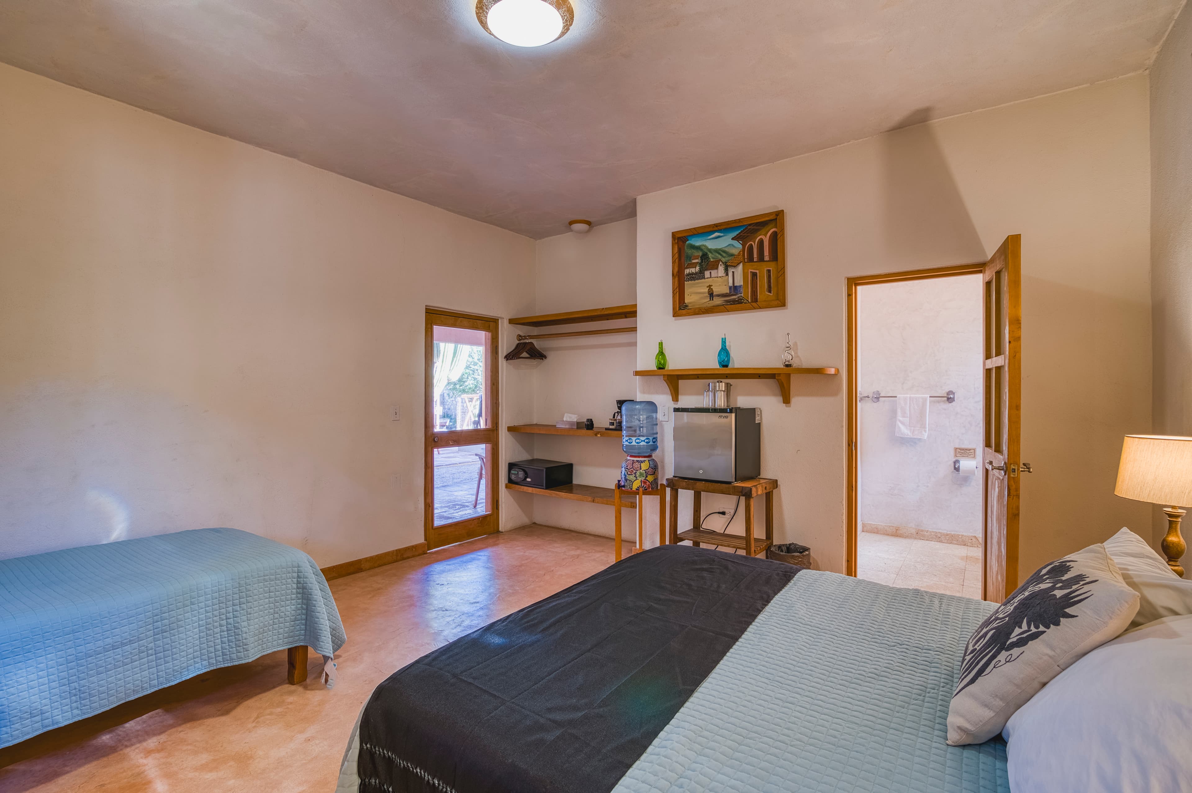 Cozy bedroom featuring two beds, a TV, and a door leading to a bathroom.