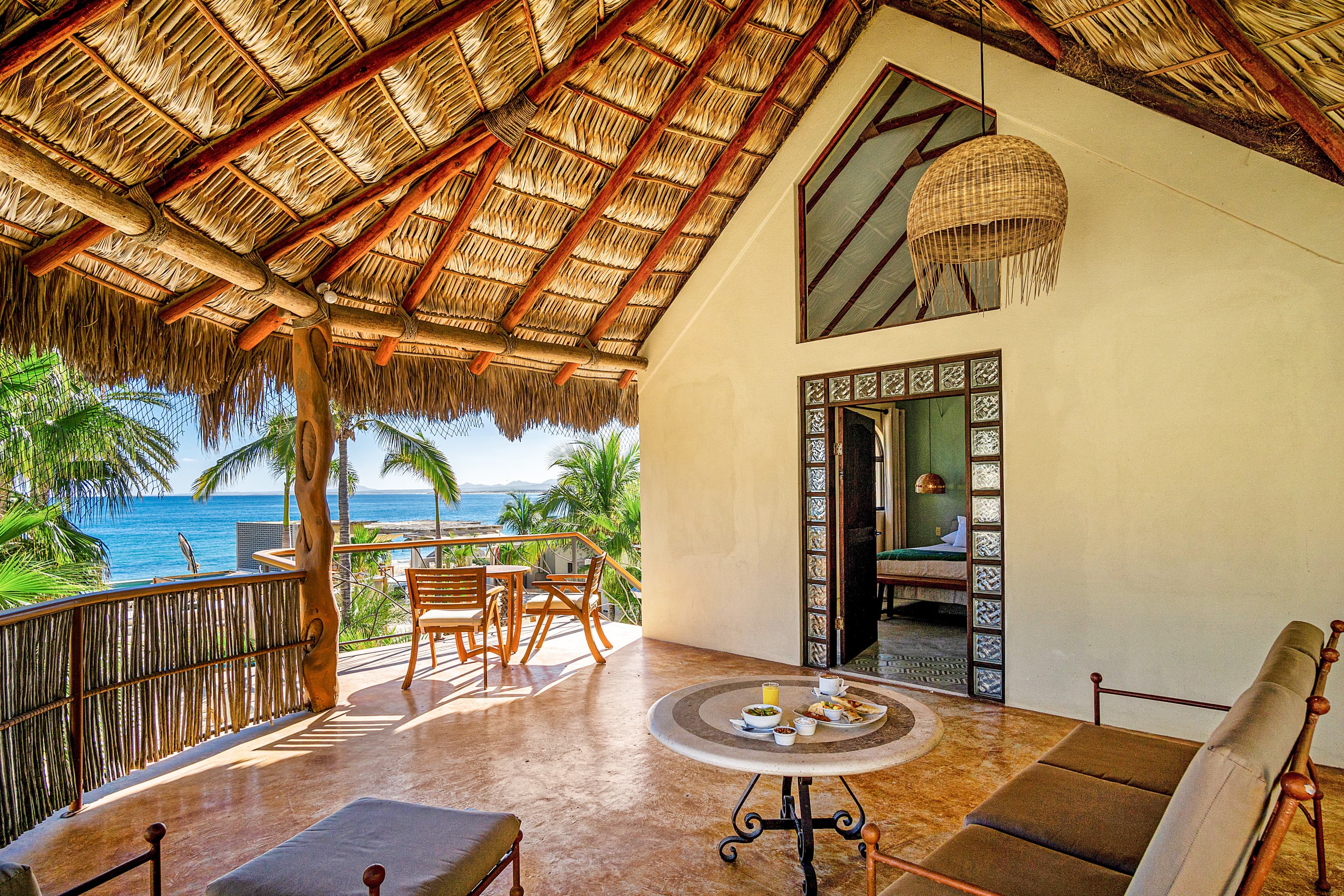 Cozy interior of a tropical beachside villa with woven ceilings and ocean views.