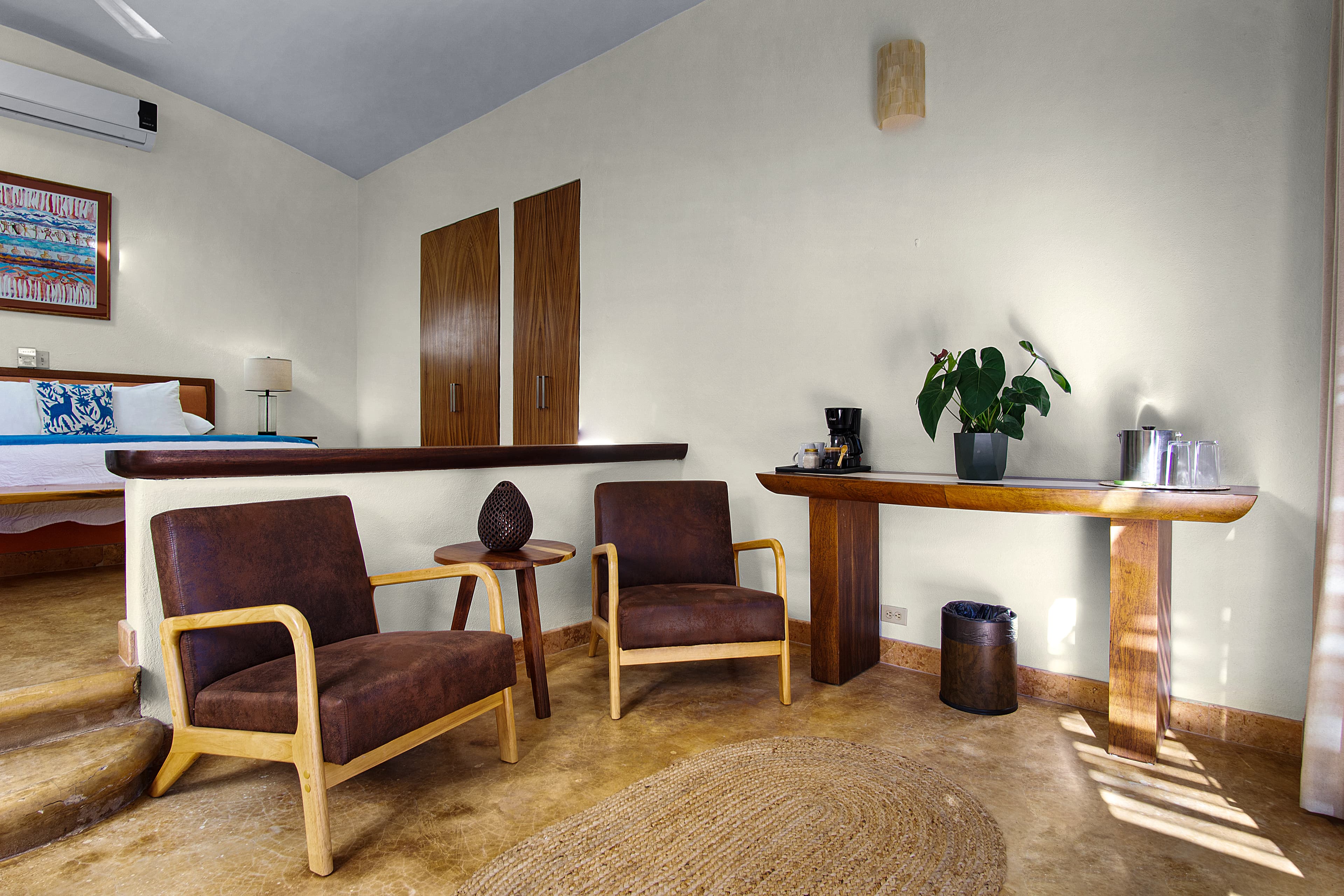 A cozy room featuring two brown chairs, a wooden table, and a potted plant.