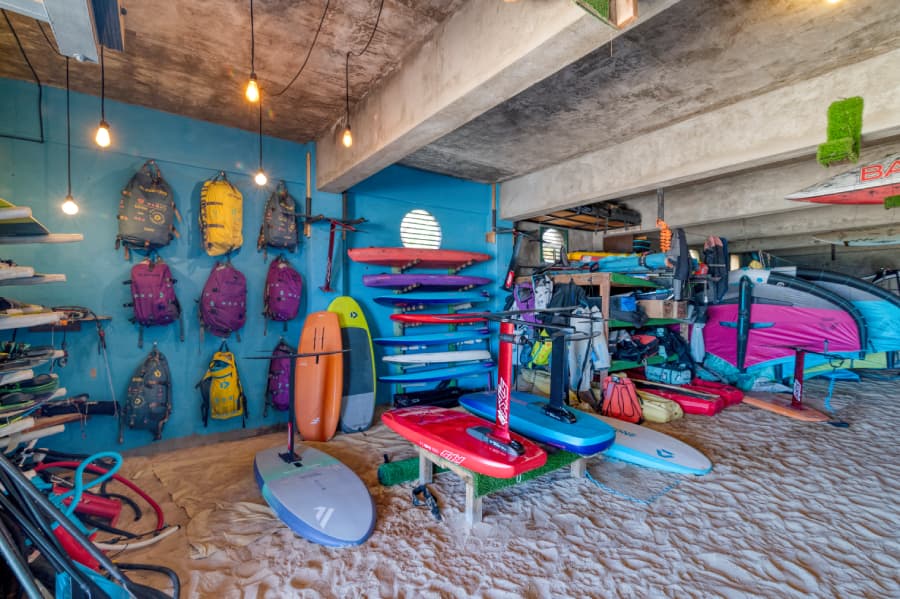 A colorful surf shop filled with various surfboards and gear against a blue wall.