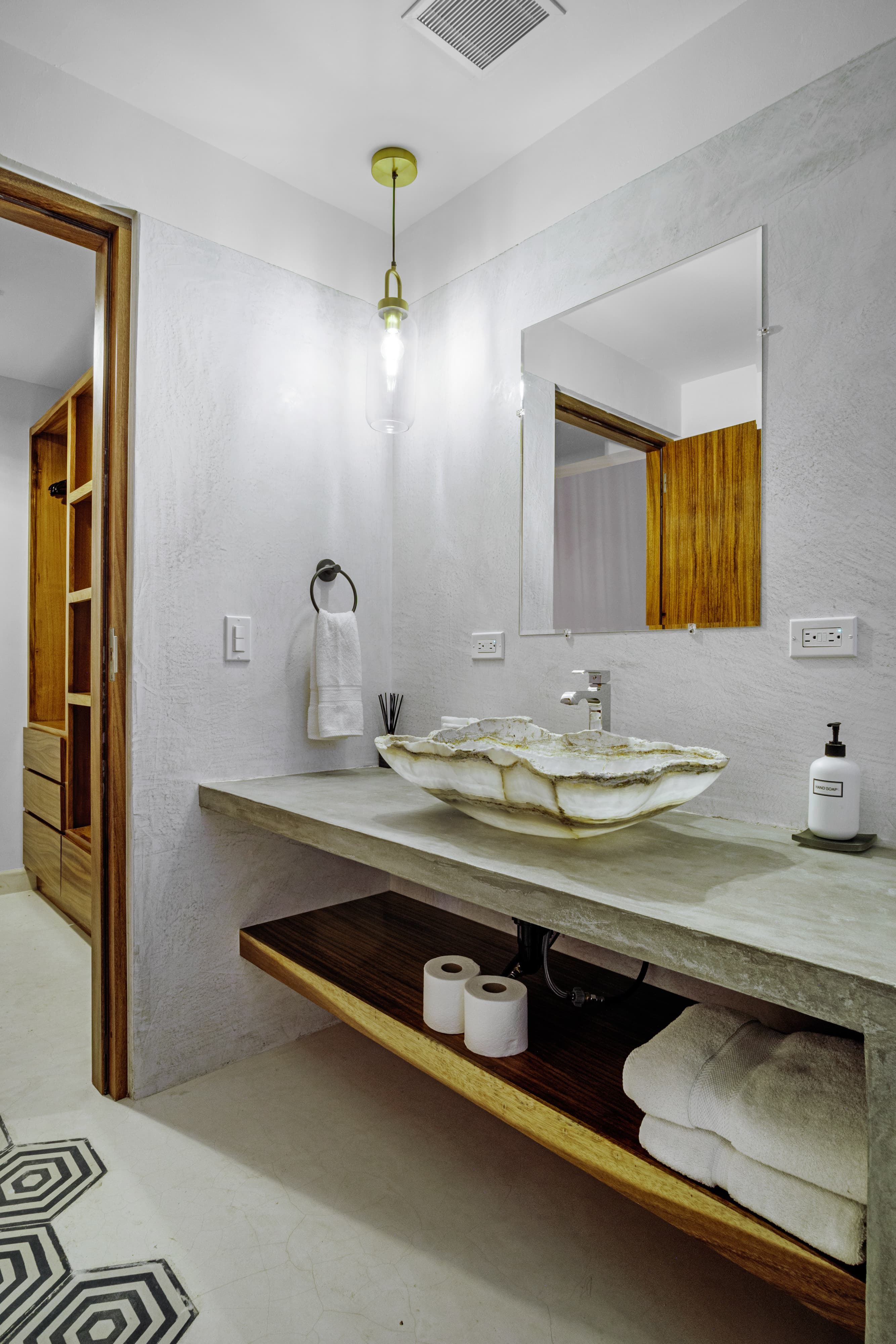 Modern bathroom with a concrete sink, wooden accents, and stylish decor.